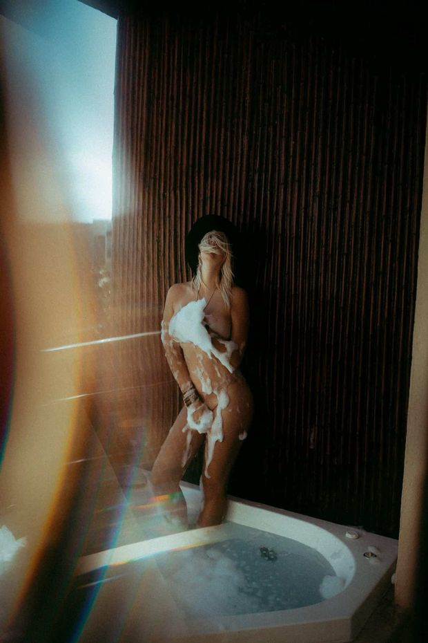 Lively blonde, has fun taking a bubble bath