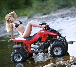 Hot blonde sitting on a four-wheeler leaning back with her legs up