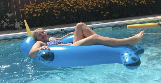 Teen floating on a pool float