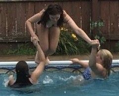 Two teens pulling their friend in the pool