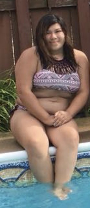 Teen sitting on the edge of the pool with her hands in her lap