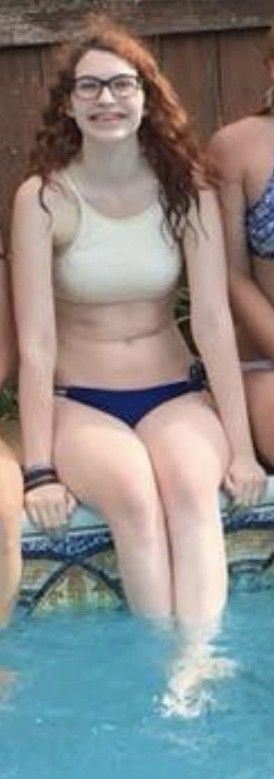 Teen sitting on the edge of the pool with her legs crossed