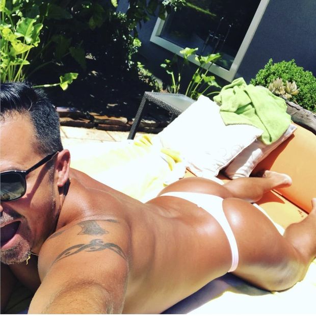 Sexy man tanning in thong