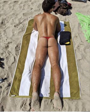 Hot ass tanning on beach in a thong