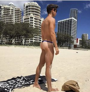 Sexy man on beach in thong with hot tan lines