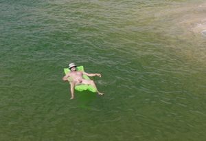 nude male sunbathing on lake