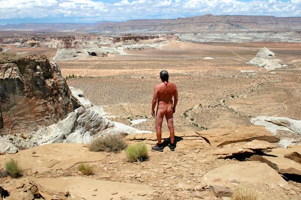 nude male hiker overlooks desert canyons