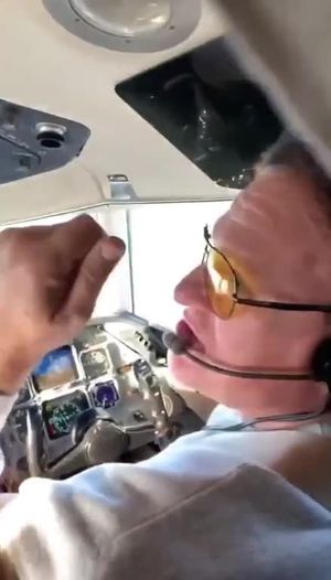 Airstewardess helps with turning knobs in the cock pit