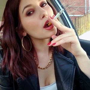 Lovely woman smoking in leather