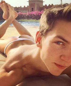 Cute guy tanning at the pool in a thong