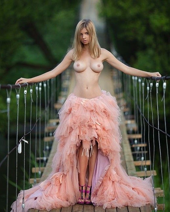 Standing topless on a bridge
