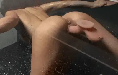 View from behind of her great ass and pussy fucking her dildo stuck to the shower glass