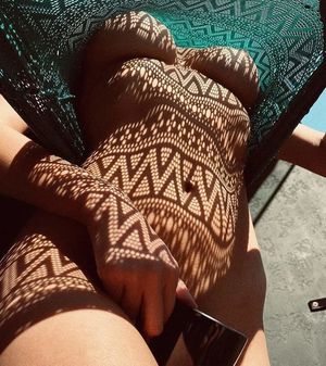 Shadows dance a lovely pattern on her skin.