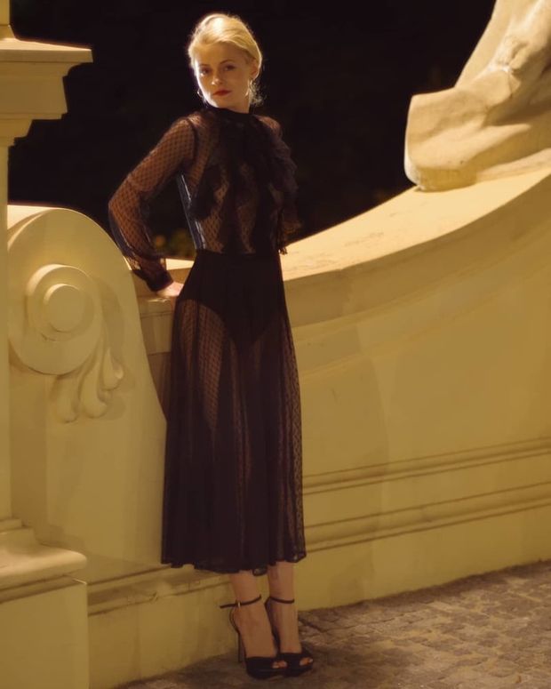 Hot blonde babe posing braless in sheer long black dress and high heeled sandals