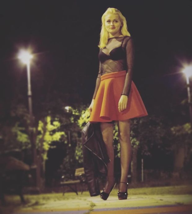 Pretty hottie posing outdoors in sheer top, short flared mini skirt and black stockings