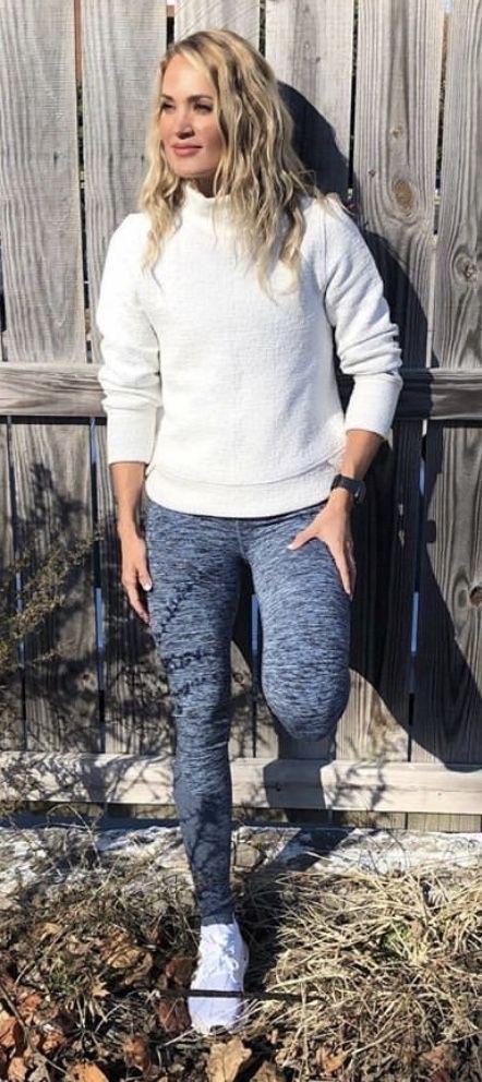 Carrie against a fence in leggings