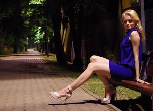 Nice blonde babe wxposing her legs outdoors in mini dress and white heels