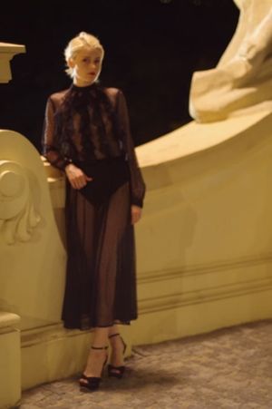 Gorgeous blonde lady in black sheer long dress and stiletto sandals