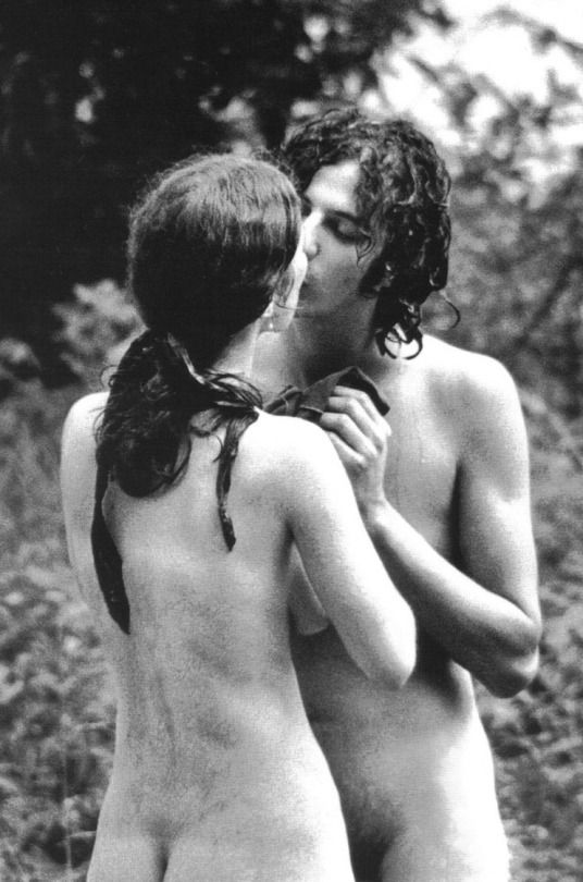 Nude hippie couple share a kiss