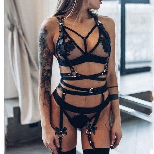 Black leather harness over black lingerie, chick with tattoos