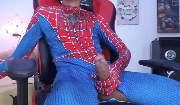 A still image from chaturbae a columbian twink named keindren jerks off in a spiderman costume, with a big cock and small dick piercing.