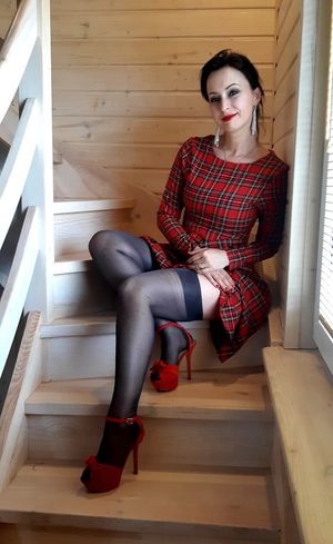 Nice brunette exposing her log legs in black stockings and red high heeled sandals