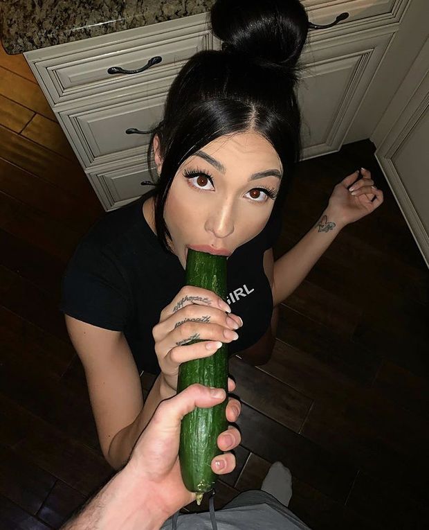 Brunette eating a cucumber