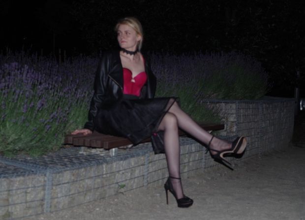 Nasty blonde chick posing outdoors in mini skirt, red top and high heeled sandals