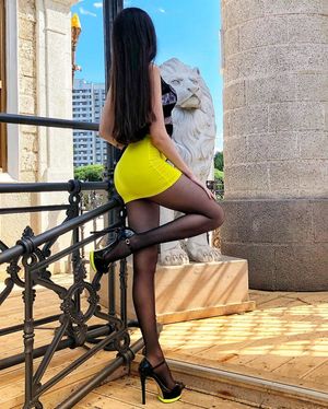 Dark hair beauty in tiny yellow mini skirt