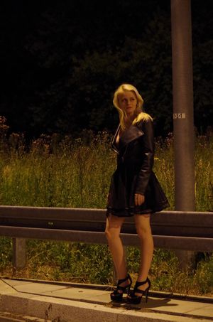 Sexy model in short loose skirt and leather jacket outdoors