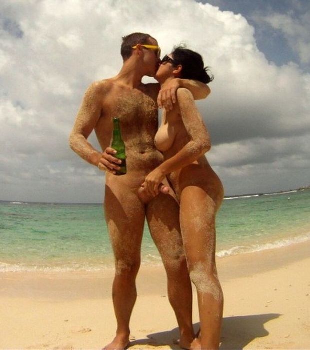 At the beach with a beer in hand and a hand on his cock