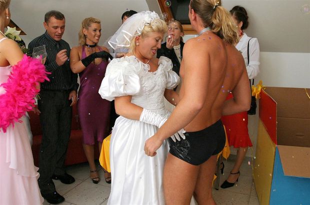 The beautiful bride undresses the guest at the party. She started a wedding sex orgy.