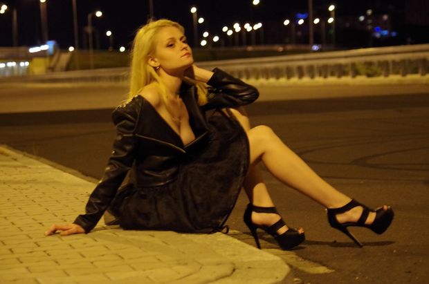 Blonde on the street braless in black leather jacket