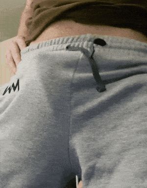 Hard cock bursting from gray sweatpants