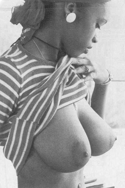 Black woman lifting up her shirt and showing her big ass titties.