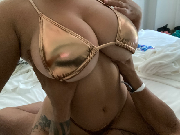 Busty chick in Gold bikini on top of her man
