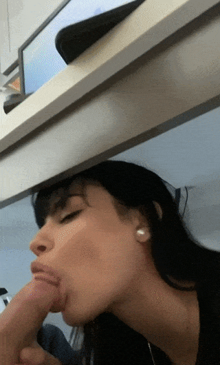 black haired hottie sneaks a blowjob from under a desk