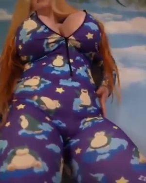 Busty woman in pajamas & boots shimmying.