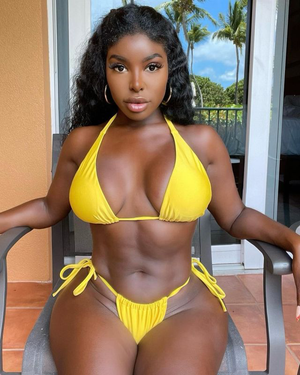 Saida Iman sitting in a chair while wearing a Yellow bikini