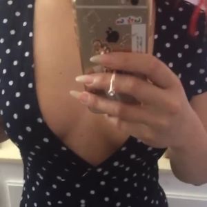 Short clip of lady with pretty nails, cleavage, hair & dress.