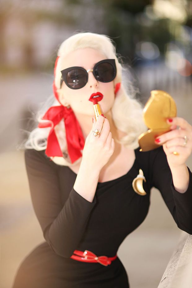 Blonde applying red lipstick
