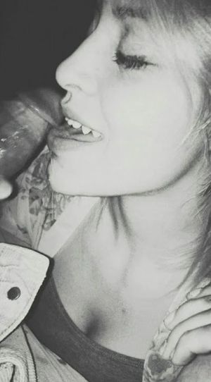 Black and white shot of a blond licking dick