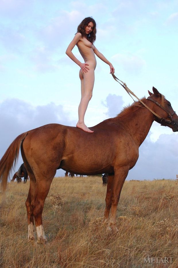 Pale skinned beauty standing on horseback