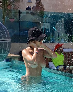 Couple gettin handsy behind Tao Wickrath at the hotel pool