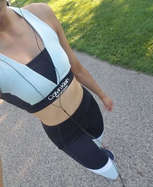 Hot white female running in cute matching sports bra & leggings