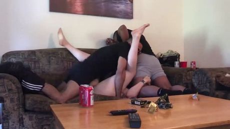 Taking a pair of black cocks on the couch