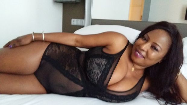 Ndey in black bodystocking on the bed, ready to play