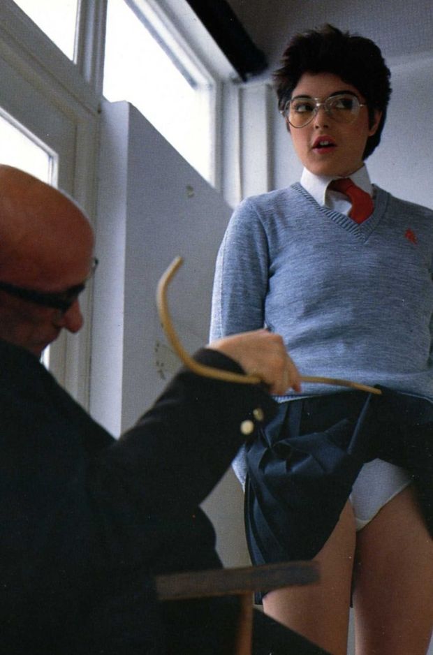Headmaster checks under student's skirt to see if she is wearing the right panties