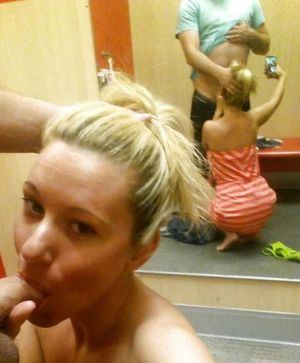Amateur blond in the dressing room giving a mirror-shot while she blows
