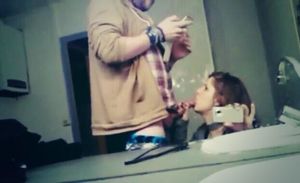 Amateur brunette taking a photo in the mirror of her blowing a dude